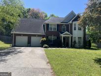 Charming two-story brick home featuring an attached two-car garage and mature landscaping in a suburban setting at 345 S Magnolia Se Walk, Atlanta, GA 30349