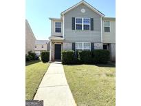 Inviting two-story townhome with manicured lawn and walkway leading to the front door at 1605 Hydrangea Ln, Mcdonough, GA 30253