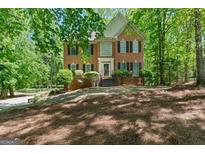Charming two-story brick home with black shutters, lush landscaping, and a welcoming front entrance at 9276 Fieldstone Ct, Jonesboro, GA 30236