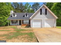 Charming two-story home with a two-car garage, dormer windows, and a cozy front porch with rocking chairs at 1012 Miss Amber Way, Locust Grove, GA 30248