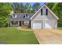 Charming two-story home with a well-manicured lawn, two car garage, and inviting front porch with rocking chairs at 1012 Miss Amber Way, Locust Grove, GA 30248