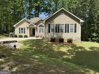 Charming single-Gathering home featuring stone accents and well-maintained landscaping on a sunny day at 992 Cove Lake Ct, Lawrenceville, GA 30045