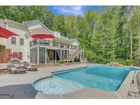 Inviting backyard pool with waterfall feature, surrounded by lounge chairs and lush greenery at 140 Horton Creek Trl, Brooks, GA 30205
