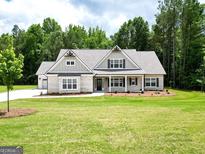 Charming one-story home featuring a brick facade, multiple gables, and a well-manicured lawn at 2109 Ella Springs Dr, Covington, GA 30014
