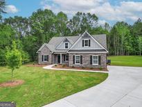 Charming brick home featuring a well-manicured lawn and concrete driveway leading to a 2-car garage at 2117 Ella Springs Dr, Covington, GA 30014