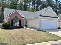 Charming single-story home with a brick facade, attached garage, and well-maintained lawn at 403 Rock Creek Dr, Peachtree City, GA 30269
