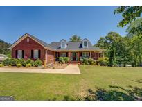 Charming brick home with covered porch, landscaped yard, and accessible ramp at 637 Lakeview Dr, Newborn, GA 30056