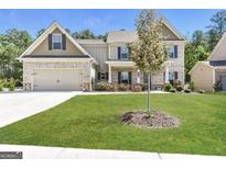 Charming two-story home with a brick facade, two-car garage, and well-maintained lawn at 1700 Cobblefield Cir, Dacula, GA 30019