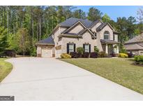 Stately brick two-story home featuring a three-car garage, a large yard, and professionally landscaped shrubbery at 266 Shellbark Dr, Mcdonough, GA 30252
