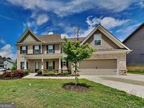 Charming two-story home with brick and siding, complemented by a well-manicured lawn at 1820 Cobblefield Cir, Dacula, GA 30019