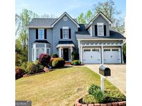Charming two-story home with a manicured lawn, two-car garage, and attractive landscaping at 1581 Shetland Pony Nw Ct, Suwanee, GA 30024
