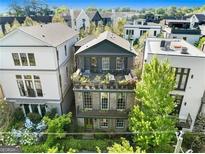 Attractive three-story home featuring dual rooftop patio areas, charming brick facade, and manicured landscaping at 558 Bismark Ne Rd, Atlanta, GA 30324
