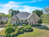 Beautiful single-Gathering home featuring manicured landscaping, a stone and siding exterior, and a well-maintained lawn at 147 Gold Bridge Xing, Canton, GA 30114