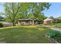 Charming brick home with a well-maintained front yard and covered parking at 264 Rockin Hill Sw Dr, Marietta, GA 30060