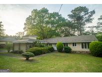 Charming home with stone accents, complemented by mature trees and lush green lawn at 4214 Smithsonia Ct, Tucker, GA 30084