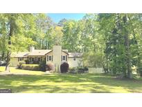 Traditional home with a manicured lawn and mature trees, providing shade and privacy at 15 Perthshire Dr, Peachtree City, GA 30269