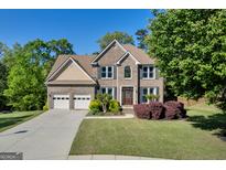 Charming two-story brick home with a well-manicured lawn and a two-car garage at 1275 Mill Shyre Way, Lawrenceville, GA 30043