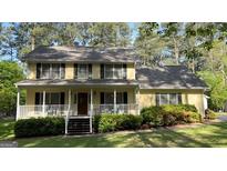 Charming two-story home featuring a welcoming front porch and lush, well-maintained landscaping at 140 Julie Rd, Tyrone, GA 30290