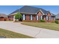 Beautiful brick home with a well-manicured lawn and extended driveway at 130 Gillson Dr, Mcdonough, GA 30253