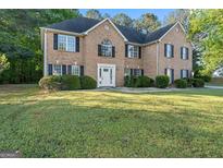 Charming brick two-story home with black shutters, white door, and well-manicured lawn at 643 Rangeley Meadows Ct, Hampton, GA 30228