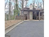 View of the home's exterior and driveway, with a carport, and landscaping at 26 Cobblestone Crk, Peachtree City, GA 30269