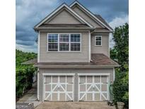 Two-story home featuring a two-car garage and a charming exterior design with large windows at 2681 Mariner Way, Villa Rica, GA 30180