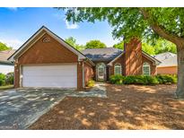 Charming brick home with a well-maintained lawn, two car garage, and inviting front entrance at 140 Carriage Chase, Fayetteville, GA 30214