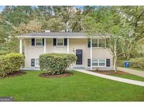 Charming two-story home features a white brick exterior, dark shutters, and a well-manicured lawn at 3798 Bakers Ferry Sw Rd, Atlanta, GA 30331