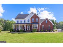 Beautiful two-story brick home with a large front lawn and covered porch, perfect for suburban living at 125 Anna Dr, Covington, GA 30014