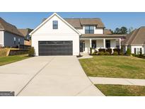 Beautiful exterior view of a two story home with a large black garage door and landscaped front yard at 15 Dayton Way, Sharpsburg, GA 30277