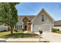 Charming two-story home featuring a two-car garage, landscaped yard and brick facade at 4893 River Overlook Way, Lithonia, GA 30038