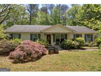 Charming ranch home with lush landscaping and a welcoming front porch at 1326 Harmony Grove Church Rd, Auburn, GA 30011