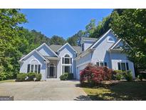 Beautiful two-story home featuring a well manicured lawn, mature trees and ample parking space in the driveway at 109 Windsong Dr, Stockbridge, GA 30281