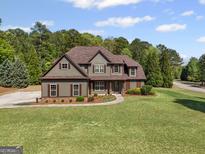 Charming two-story home with a well-manicured lawn, detailed trim and a walkway to the front door at 189 Willowleaf Way, Sharpsburg, GA 30277