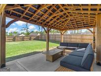 Outdoor patio featuring a large seating area, fire pit, and spacious, fenced backyard at 150 Ivy Chase Loop, Dallas, GA 30157