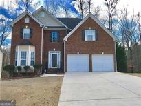 Charming two-story brick home with a two-car garage and well-maintained front yard at 3215 Rose Petal Ln, Powder Springs, GA 30127