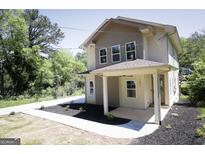 Charming two-story home featuring beige siding, a welcoming front porch, and a well-manicured front yard at 185 Wadley Nw St, Atlanta, GA 30314