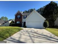 Charming two-story home featuring a brick and vinyl exterior, a two-car garage, and a well-maintained front yard at 435 Cedarhurst Rd, Lawrenceville, GA 30045
