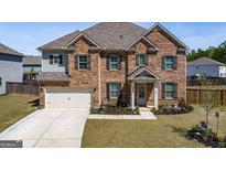 Stunning two-story brick home with a two-car garage, landscaped front yard, and welcoming entrance at 7435 Ansley Park Way, Cumming, GA 30028