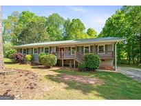 Charming single-story home with a wooden porch, gray siding, and a well-manicured lawn at 1256 Horsley Mill Rd, Carrollton, GA 30116