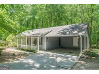 Charming single-story home with a covered carport and welcoming front porch, nestled among lush trees at 146 Highland Cir, Mcdonough, GA 30253