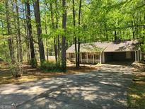 Charming home nestled among mature trees with a quaint front porch and convenient carport at 146 Highland Cir, Mcdonough, GA 30253