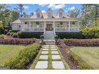 Inviting two-story home with a charming front porch and beautiful landscaped walkway at 105 Suffolk Pl, Fayetteville, GA 30215