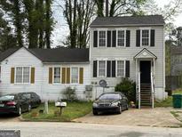 Two-story house with white siding, black shutters, a driveway and yard in need of some TLC at 3464 Kingswood Trl, Decatur, GA 30034