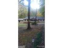 Single-story home featuring a screened porch and neutral siding nestled among mature trees at 40 Burma Rd, Mcdonough, GA 30252