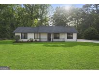 Charming single-story home featuring a well-manicured lawn and a classic design at 389 Rosser Rd, Mcdonough, GA 30252