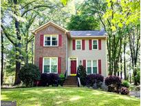 Charming two-story home with red shutters and a well-manicured lawn and mature landscaping at 110 Cedar Creek Ct, Fayetteville, GA 30215