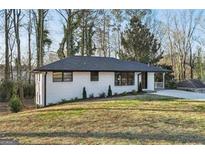 Charming single-story home with a white brick exterior and a well-manicured front yard at 1120 Starline Dr, Smyrna, GA 30080