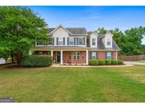 Charming two-story home featuring a welcoming front porch, brick accents, and a well-manicured lawn at 220 Calli Ct, Mcdonough, GA 30252