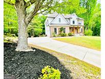 Beautiful brick and white home with a long driveway and mature trees at 2870 Willow Wisp Way, Cumming, GA 30040